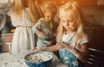 Kids is playing with flour in the kitchen